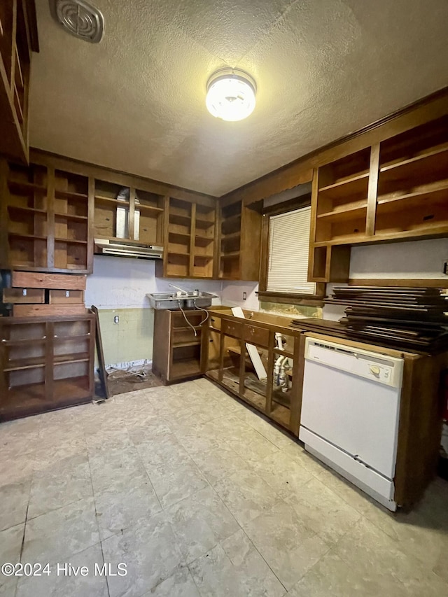 kitchen featuring white dishwasher and a textured ceiling