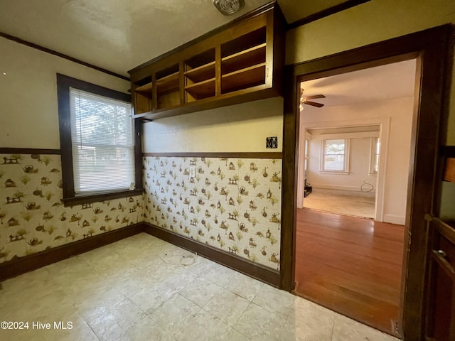 interior space featuring ceiling fan, a healthy amount of sunlight, ornamental molding, and light hardwood / wood-style flooring