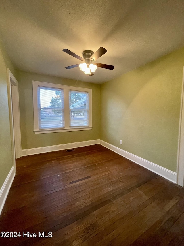 spare room featuring ceiling fan, dark hardwood / wood-style flooring, and a textured ceiling