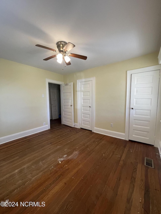 unfurnished bedroom featuring ceiling fan and dark wood-type flooring