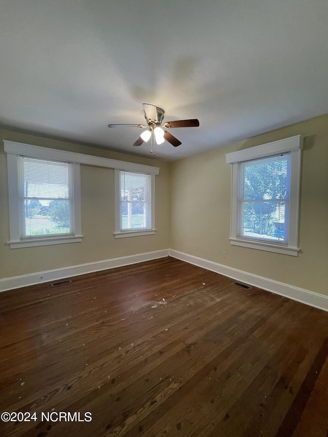 empty room with dark hardwood / wood-style flooring and ceiling fan