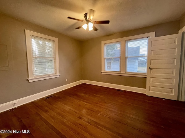 spare room featuring a textured ceiling, dark hardwood / wood-style floors, and ceiling fan