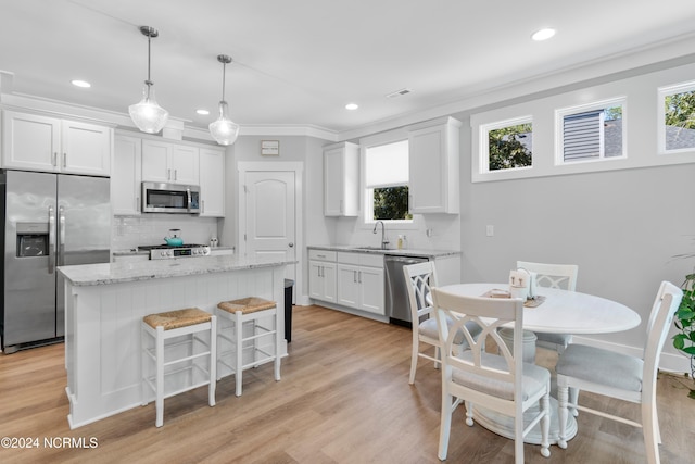 kitchen with white cabinetry, a healthy amount of sunlight, appliances with stainless steel finishes, and a kitchen island