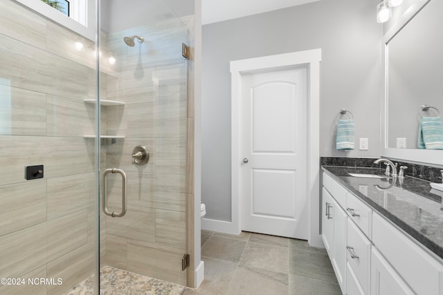 bathroom featuring vanity, toilet, and a shower with door