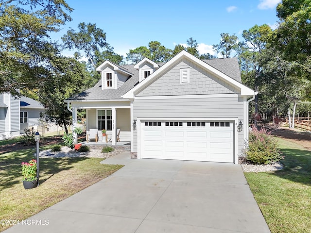 view of front of house with a front yard, a garage, and covered porch