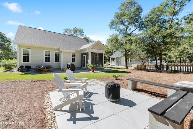 back of property featuring a patio and an outdoor fire pit