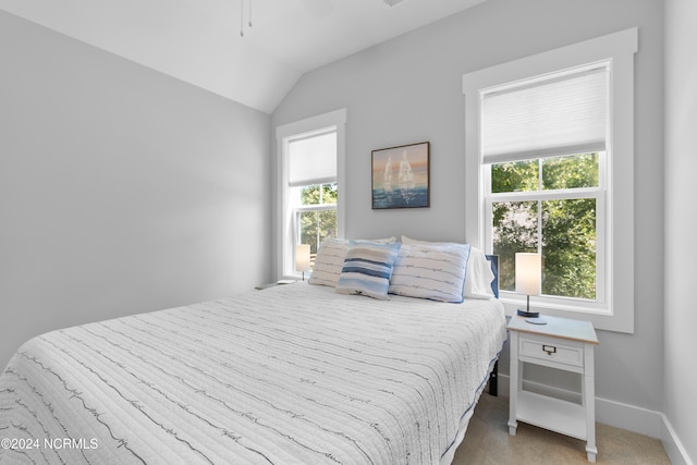 carpeted bedroom featuring multiple windows and vaulted ceiling