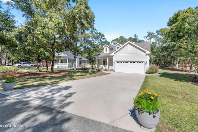 view of front of property featuring a front lawn, covered porch, and a garage