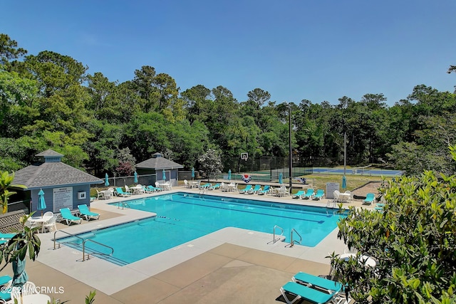 view of swimming pool featuring a patio and an outbuilding