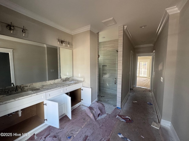 full bath featuring a stall shower, crown molding, baseboards, and a sink