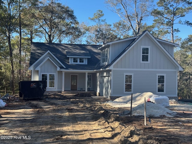 rear view of house featuring covered porch and board and batten siding