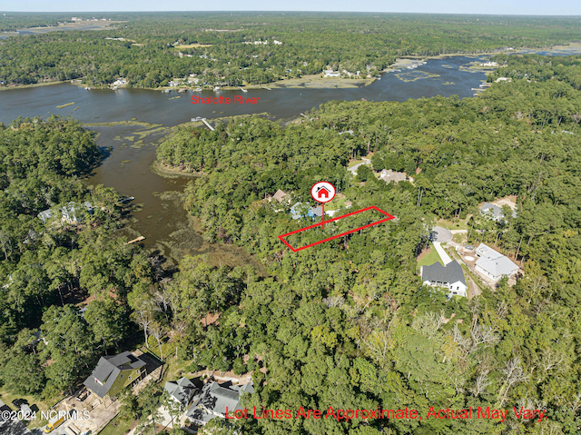 drone / aerial view with a water view and a forest view