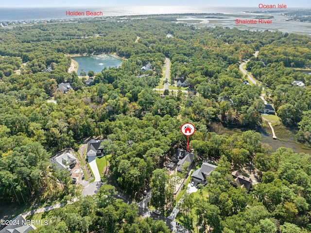 birds eye view of property with a water view and a wooded view