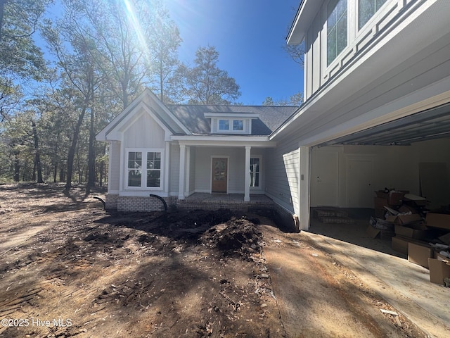 view of property exterior featuring a porch and a garage