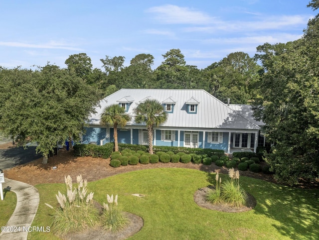 cape cod-style house with a standing seam roof, metal roof, and a front yard