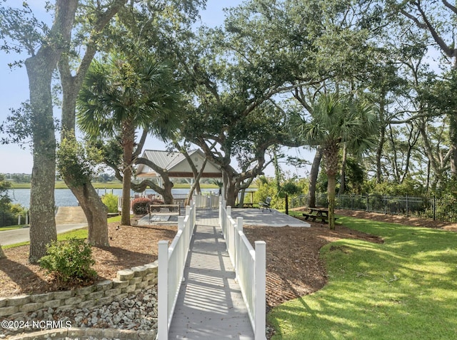 view of property's community featuring a gazebo, a yard, a water view, and fence