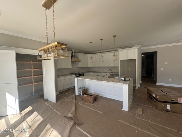 kitchen with a kitchen island with sink, white cabinetry, ornamental molding, decorative backsplash, and wall chimney exhaust hood