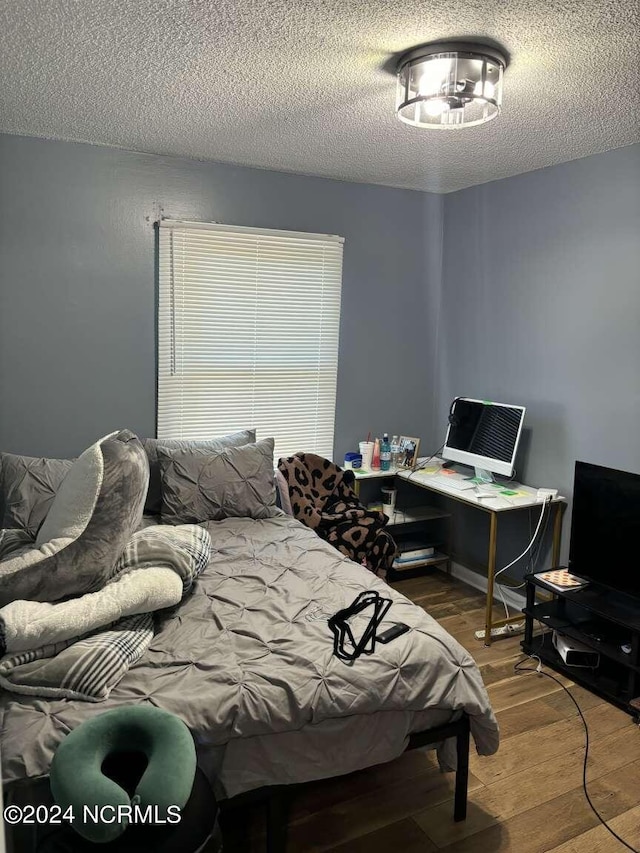 bedroom featuring a textured ceiling and hardwood / wood-style flooring