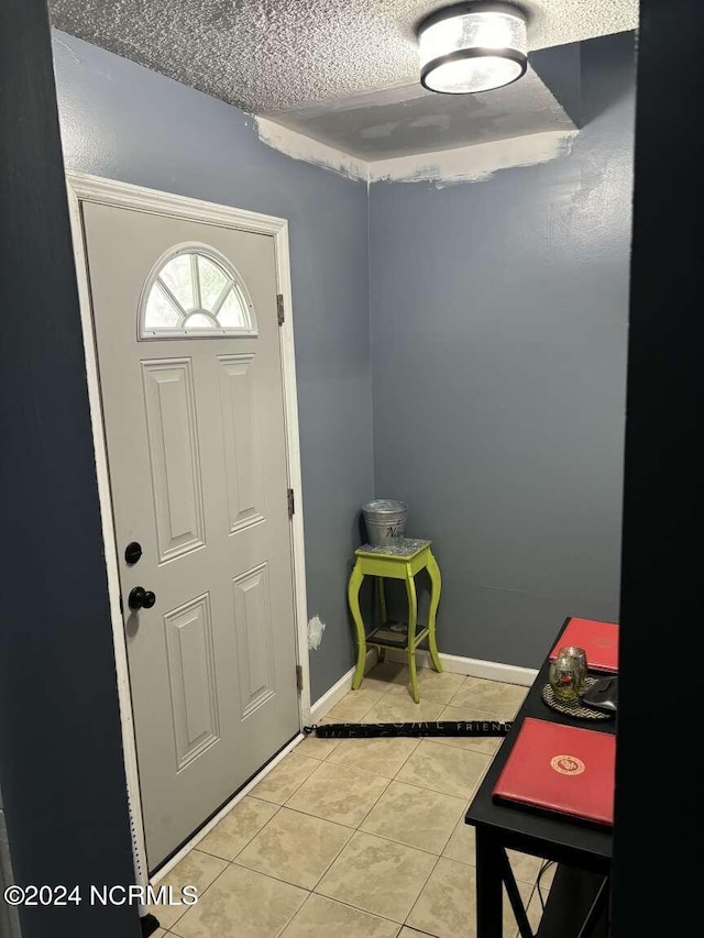 tiled foyer entrance featuring a textured ceiling