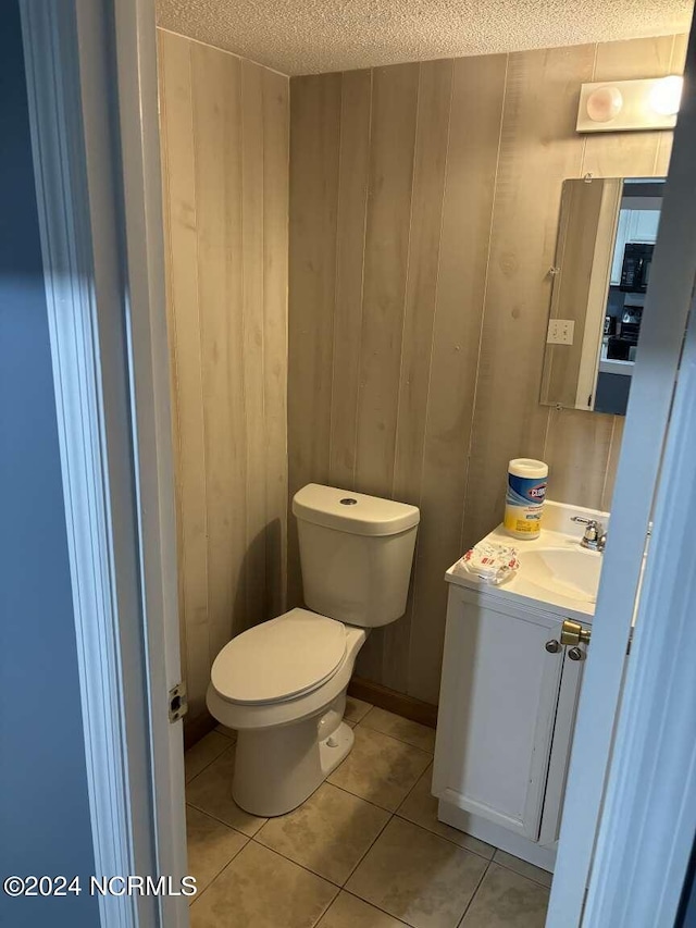 bathroom with vanity, a textured ceiling, toilet, and tile patterned floors