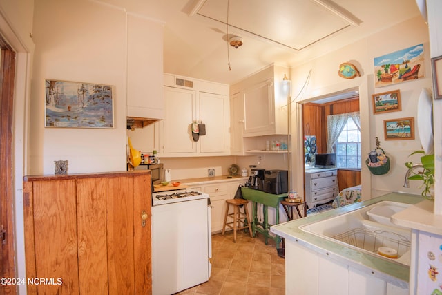 kitchen featuring white cabinets and white stove