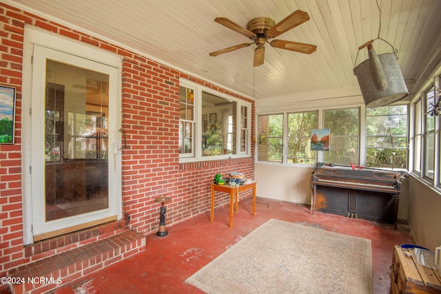 unfurnished sunroom featuring wood ceiling and ceiling fan