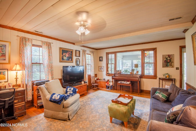 living room with ornamental molding, a wealth of natural light, and hardwood / wood-style floors