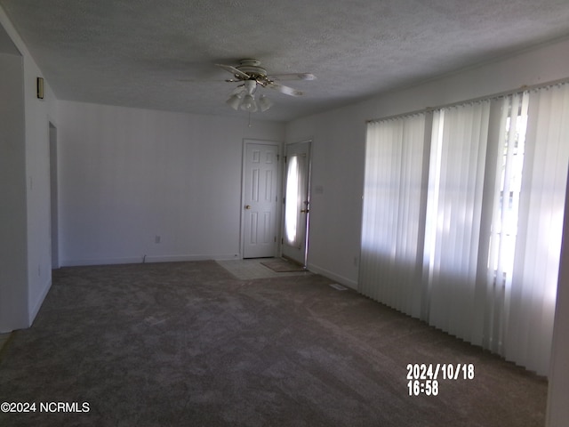 interior space with a textured ceiling, a healthy amount of sunlight, and ceiling fan