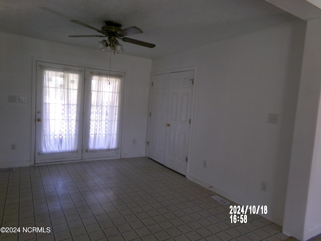 tiled spare room featuring ceiling fan