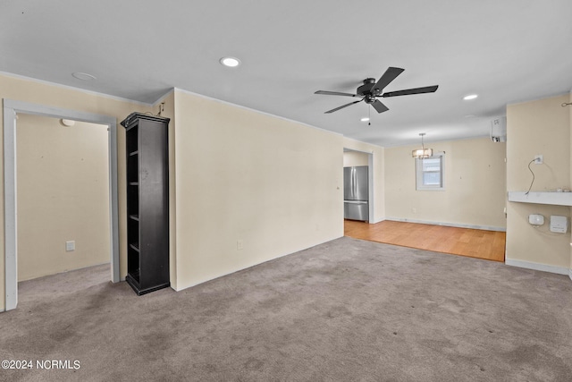 unfurnished living room with carpet and ceiling fan