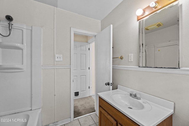 bathroom featuring tile patterned flooring, a washtub, and vanity