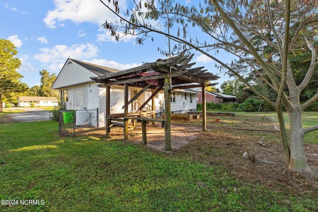 rear view of house with a pergola and a yard