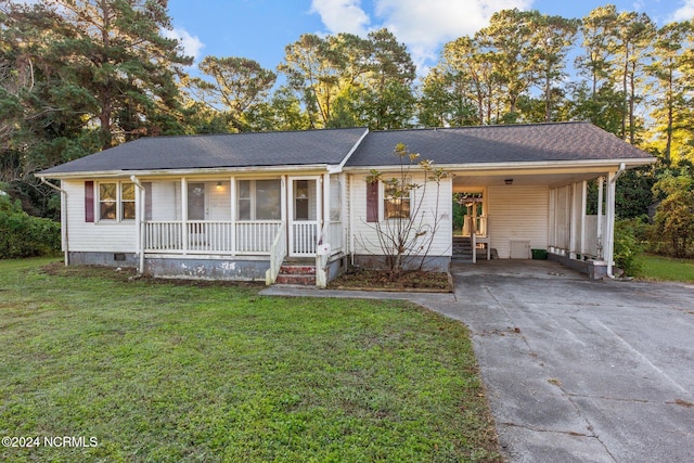 ranch-style house featuring covered porch, a front yard, and a carport