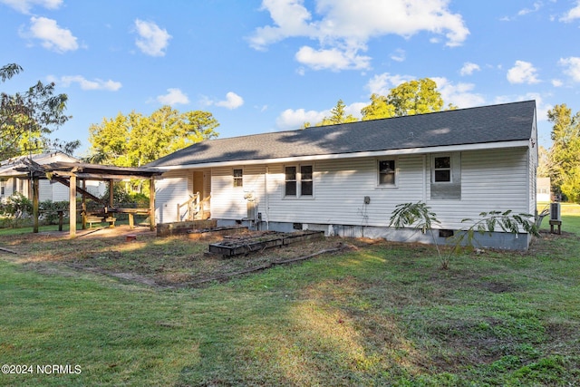 rear view of property featuring a lawn