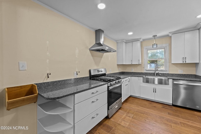 kitchen featuring white cabinetry, sink, wall chimney exhaust hood, and stainless steel appliances