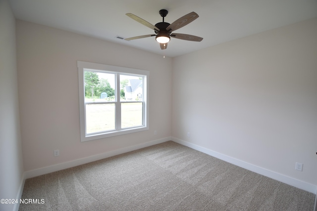 carpeted spare room featuring ceiling fan