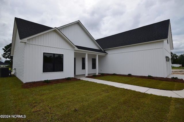 modern farmhouse style home with a front yard and cooling unit