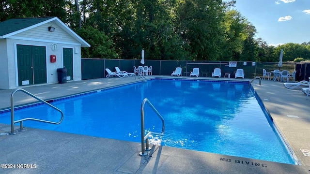 view of pool with an outdoor structure and a patio area