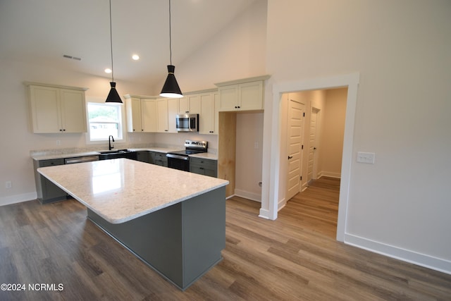 kitchen featuring dark wood-type flooring, stainless steel appliances, sink, and a kitchen island