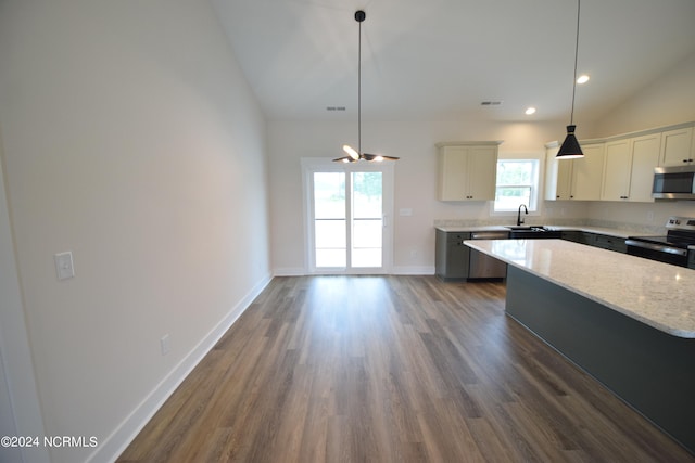 kitchen featuring a wealth of natural light, a center island, appliances with stainless steel finishes, and vaulted ceiling