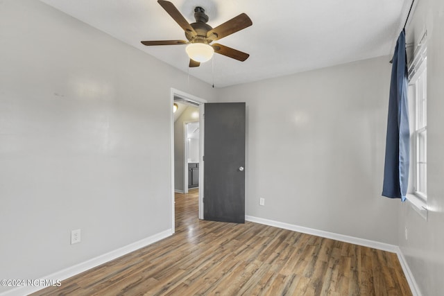 unfurnished room featuring baseboards, ceiling fan, and wood finished floors