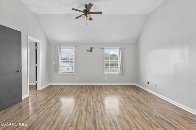 spare room with baseboards, a ceiling fan, vaulted ceiling, and wood finished floors