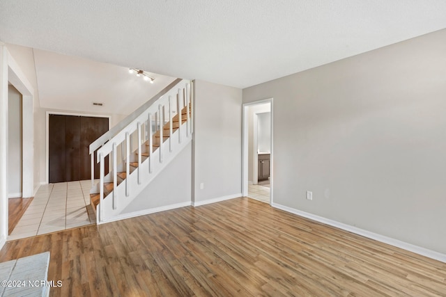 unfurnished living room with wood-type flooring and a textured ceiling