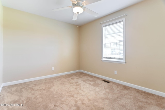 empty room featuring ceiling fan and light colored carpet