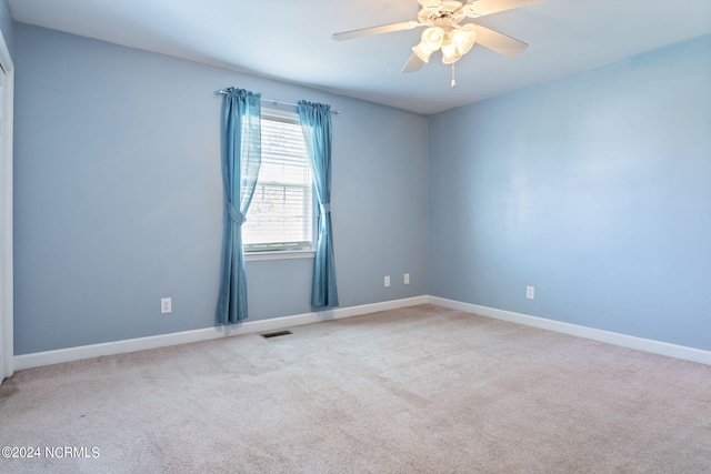 carpeted spare room with ceiling fan