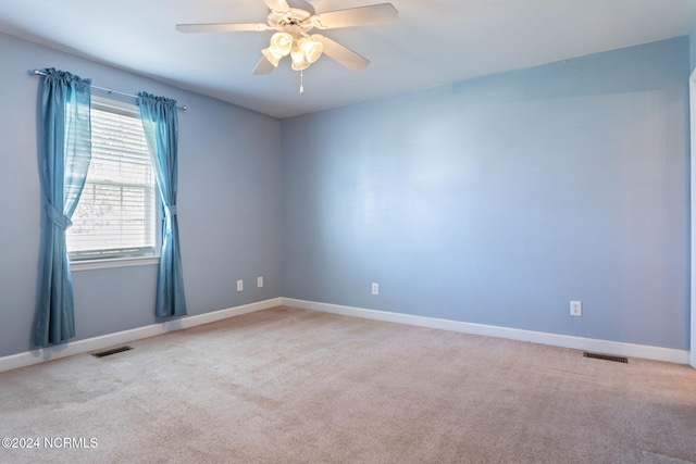 carpeted spare room featuring ceiling fan