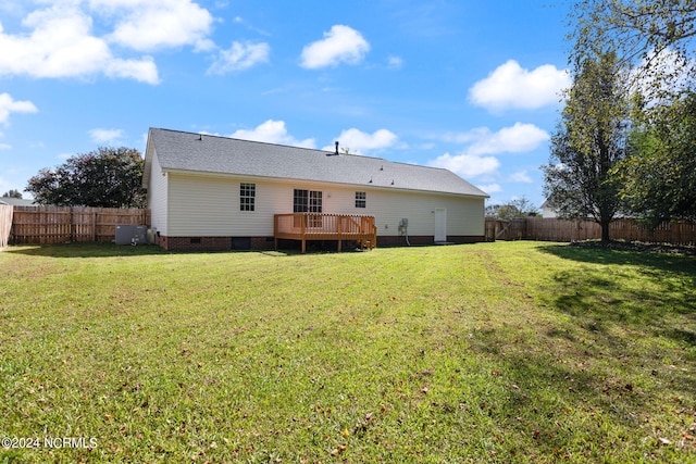 back of property with a wooden deck and a yard