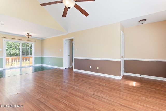 empty room featuring ceiling fan, high vaulted ceiling, crown molding, and hardwood / wood-style floors