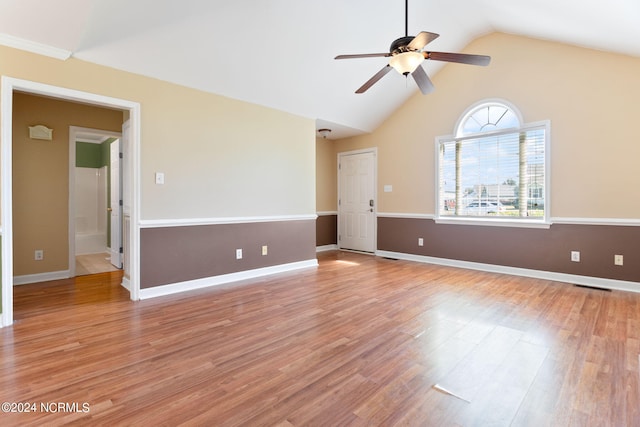 empty room with ceiling fan, lofted ceiling, and light hardwood / wood-style flooring