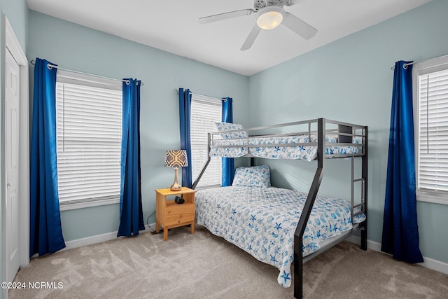 bedroom with ceiling fan, light carpet, and multiple windows